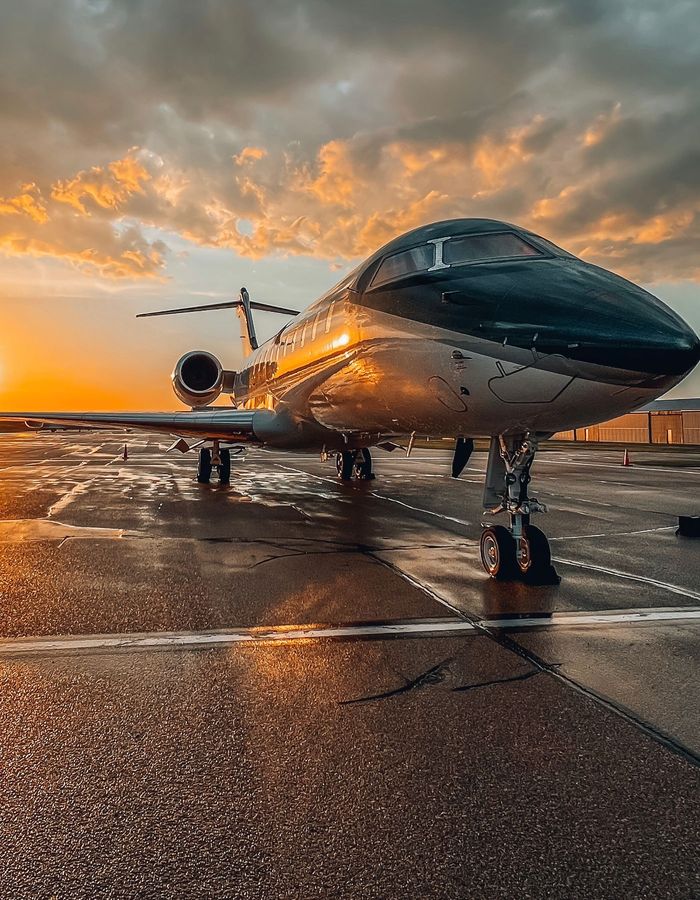 Jet privado en la pista al atardecer, con cielo dramático de fondo