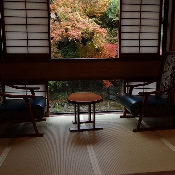 Habitación tradicional con tatami y vista a un jardín de otoño en Japón